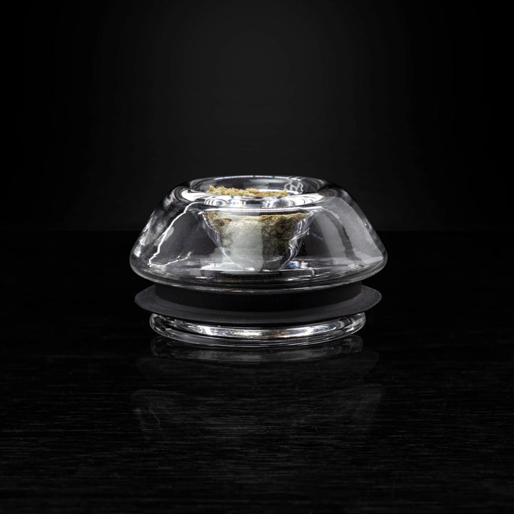 Puffco Proxy Flower Bowl on black reflective surface, showcasing its sleek glass design for dry herb use with Puffco vaporizers.