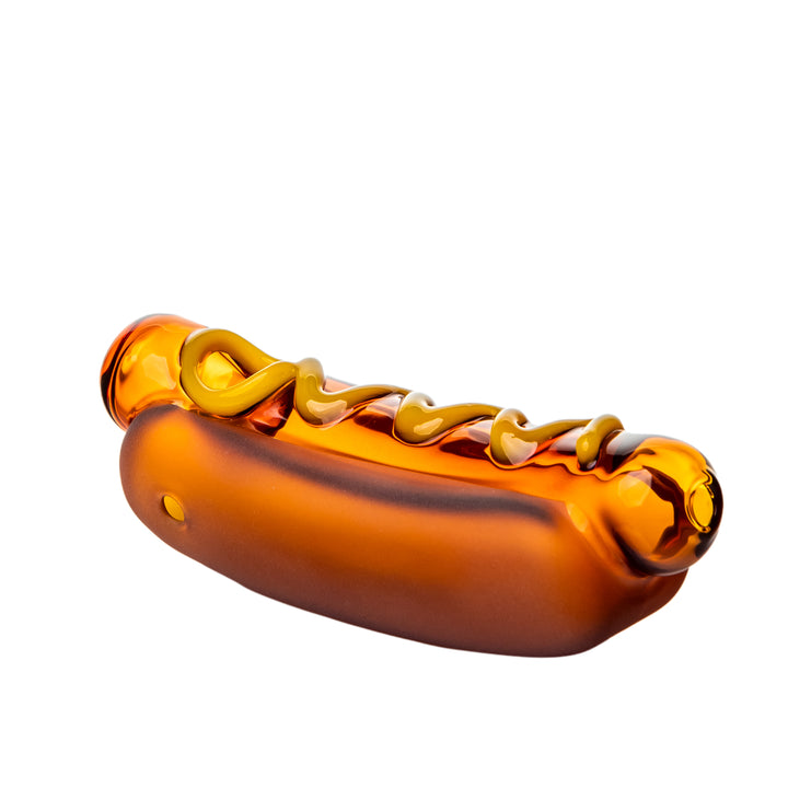 BigFun! Glizzy Hand Pipe shown at a left angle, a handcrafted borosilicate glass hot dog with a full-color bun and a raised mustard swirl running the length of the top