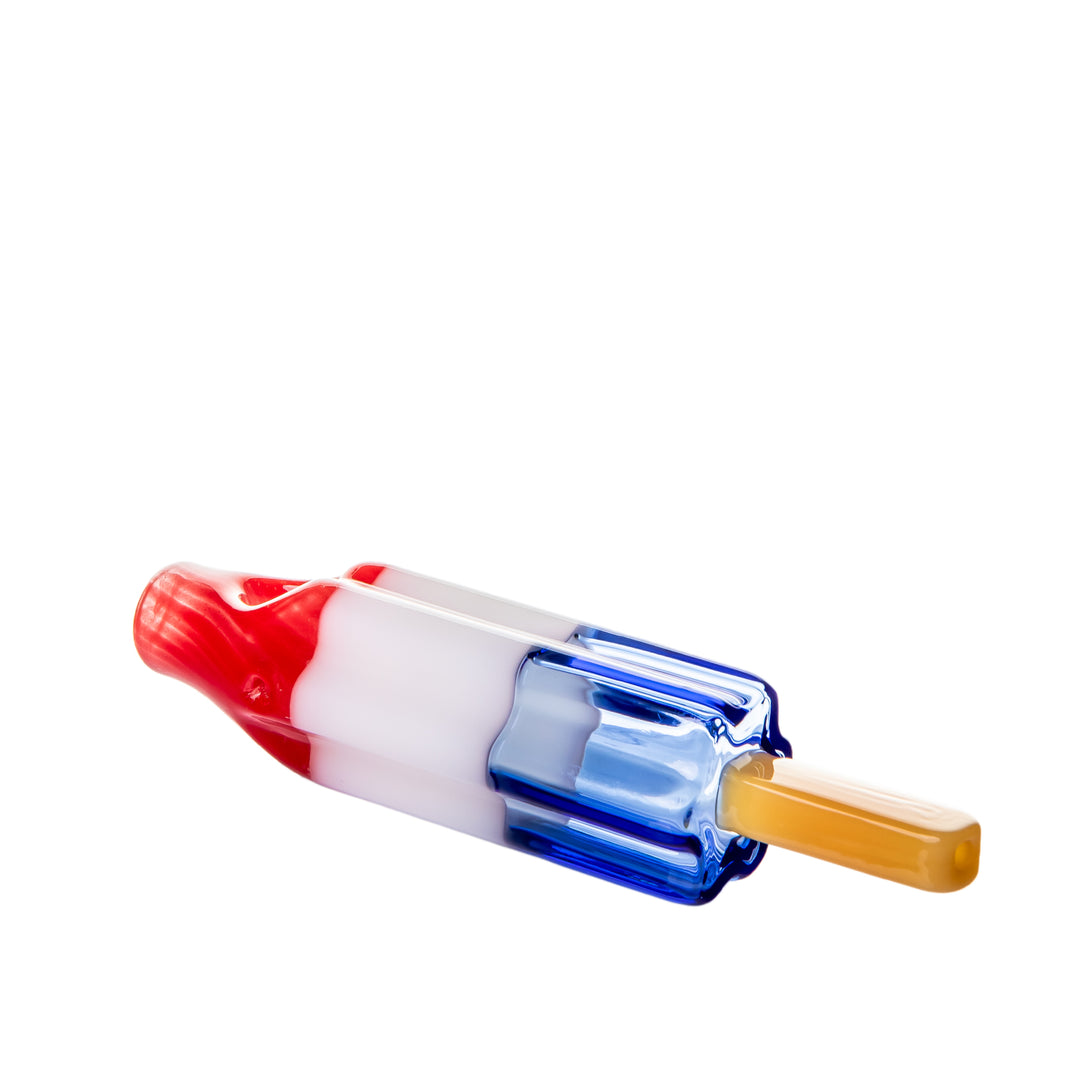 Angled left-side view of the BigFun! Pipesicle Red White Blue glass hand pipe, showing the tapered rocket-pop silhouette
