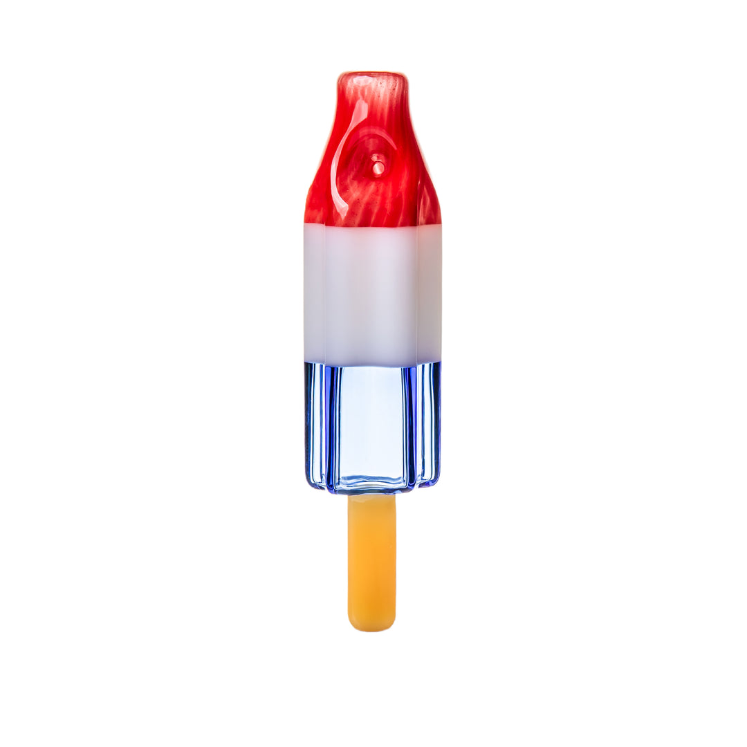 BigFun! Pipesicle Red White Blue hand pipe standing vertically, a 6-inch handcrafted borosilicate glass rocket popsicle in red, white, and blue with a glass stick at the base