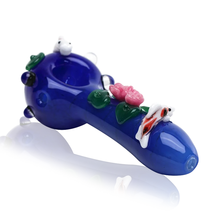 Empire Glassworks Koi Pond Pipe Small – cobalt blue spoon pipe with a white-and-orange koi on the bowl rim, pink lotus flowers and green lily pads