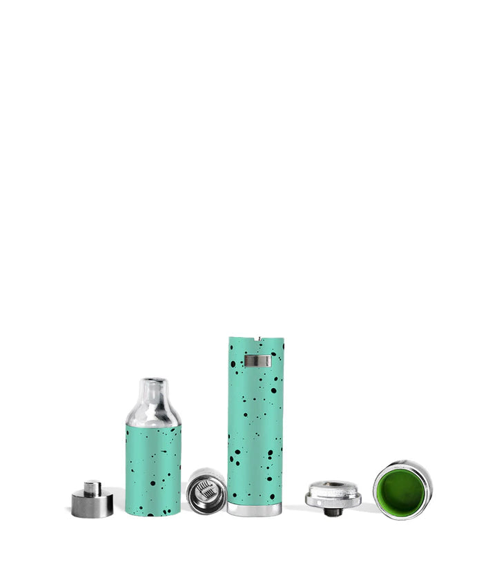 Angled kit shot of the Evolve Plus in Teal–Black Splatter showing vaporizer, coil cap, spare parts, and included loading tool.