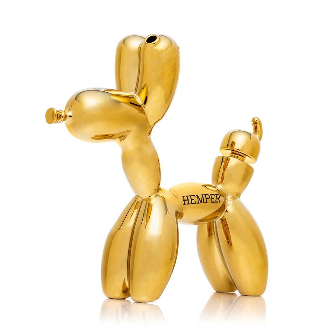 Hemper Balloon Dog XL Bong at an angle from the front left, showing the gold electroplated balloon-animal form with the ear mouthpiece and tail bowl