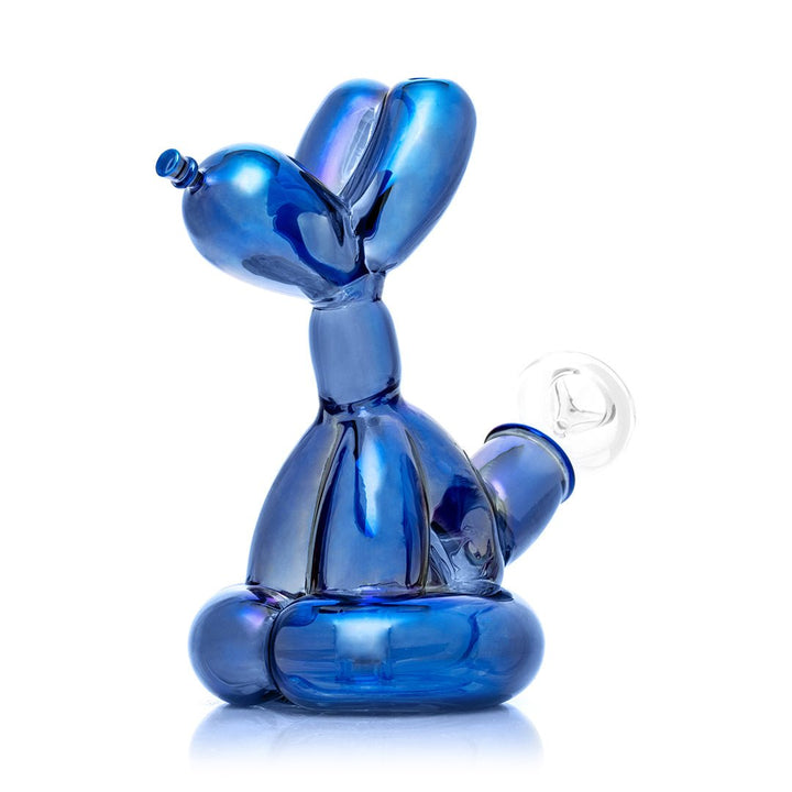 Hemper Sitting Balloon Dog Bong at an angle from the front left, showing the iridescent blue balloon-animal form with the ear mouthpiece and tail bowl