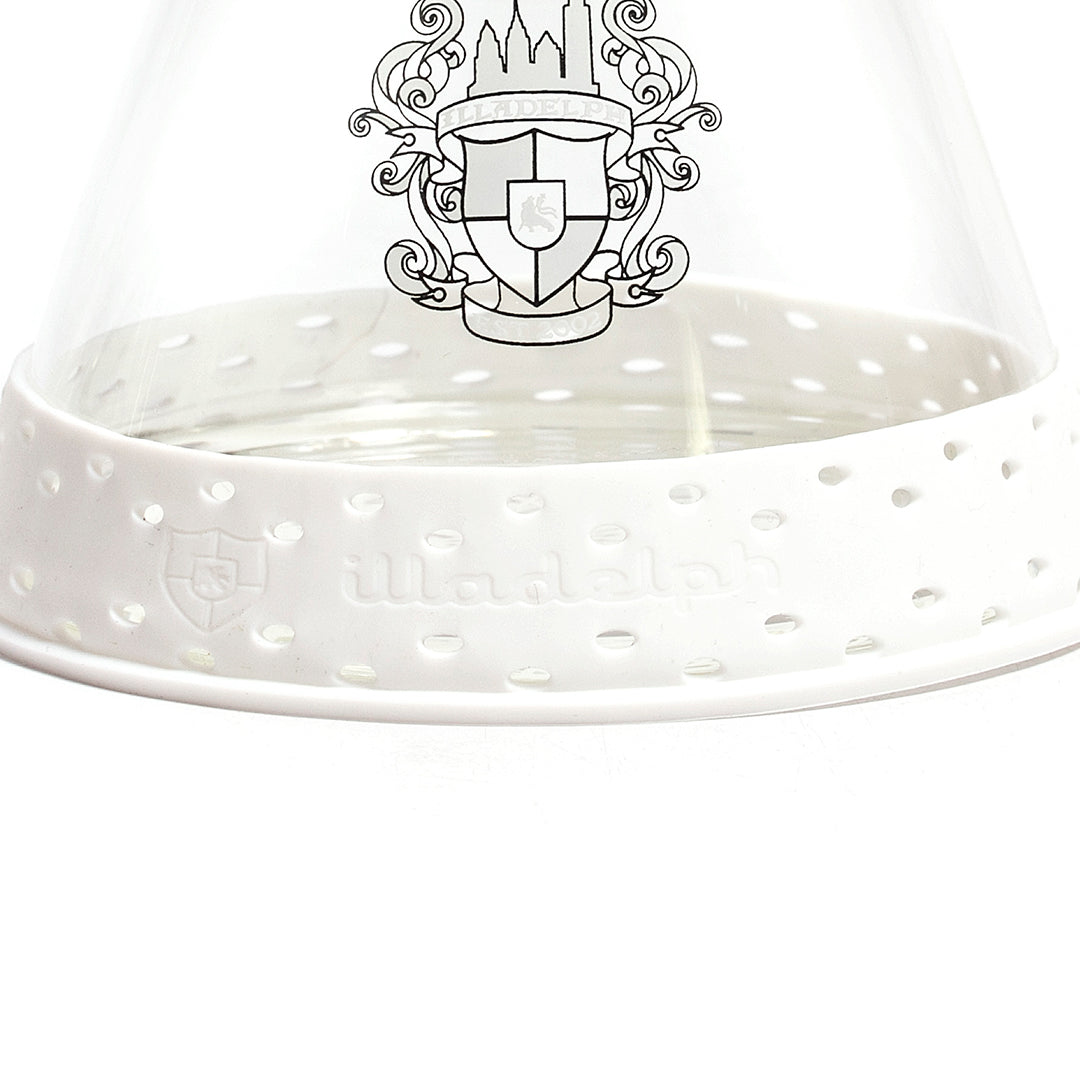 White Illadelph silicone base bumper supporting a clear Illadelph mini beaker illustrating added grip and scratch protection on flat surfaces