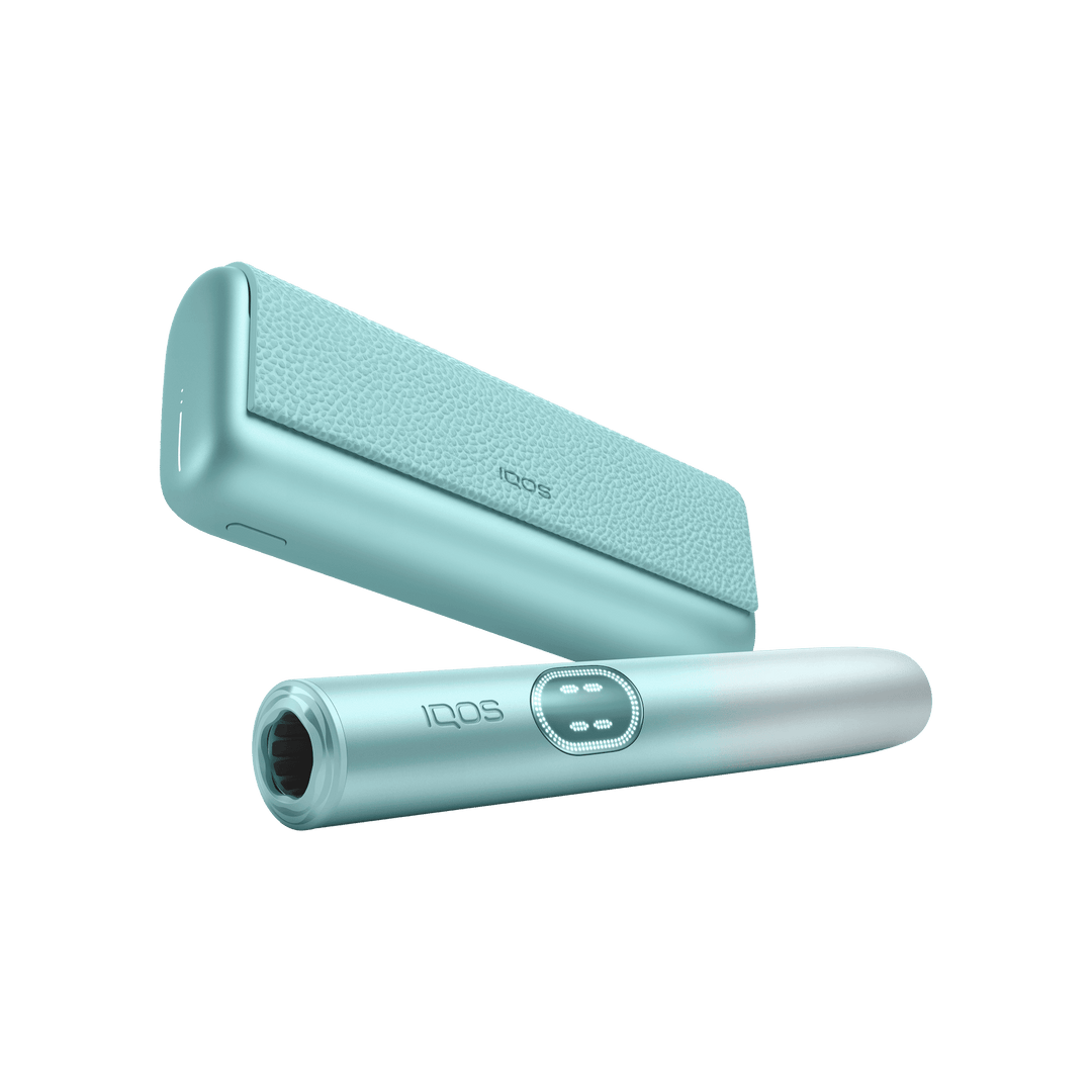 IQOS ILUMA i PRIME Breeze Blue holder in front of the pocket charger, low angle showing the mouth end