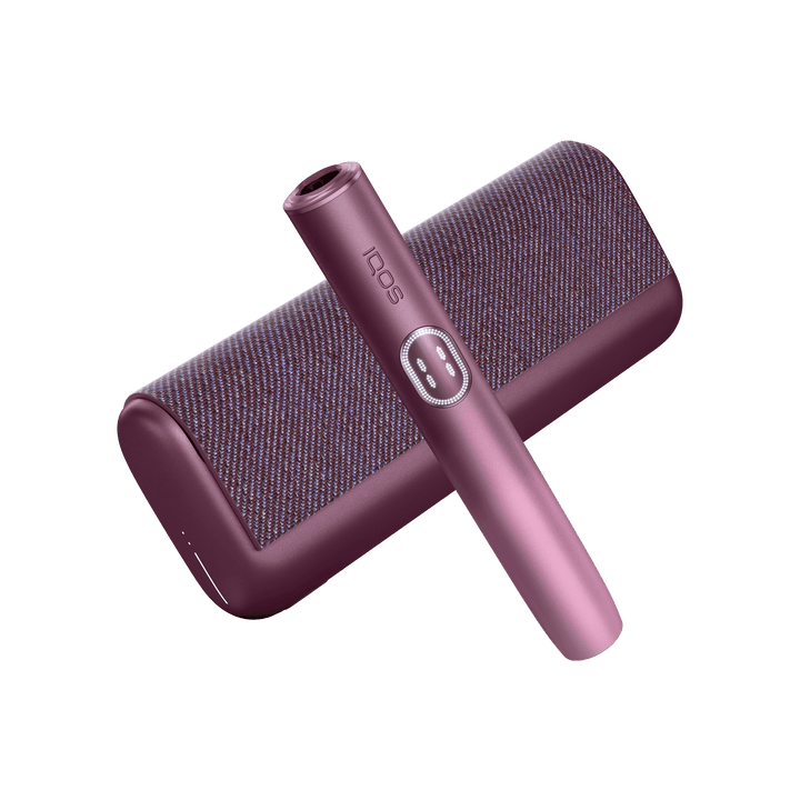 IQOS ILUMA i PRIME Garnet Red holder laid diagonally across the closed textured pocket charger