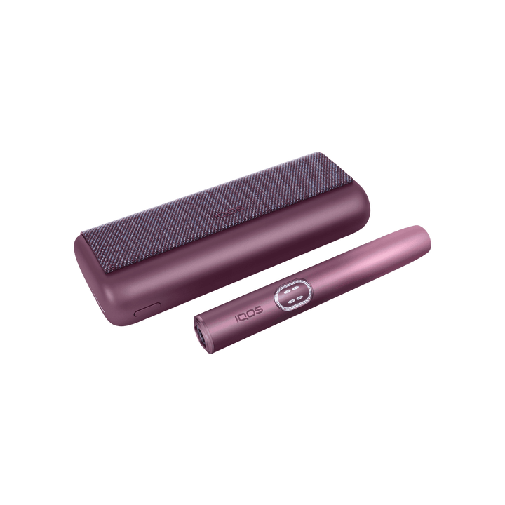 IQOS ILUMA i PRIME Garnet Red closed pocket charger lying flat with the holder beside it