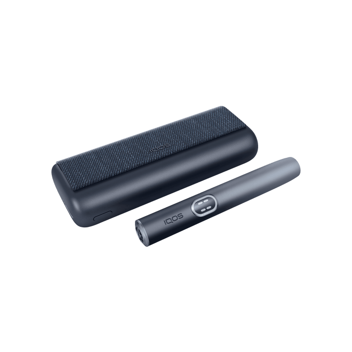 IQOS ILUMA i PRIME Midnight Black closed pocket charger lying flat with the holder beside it