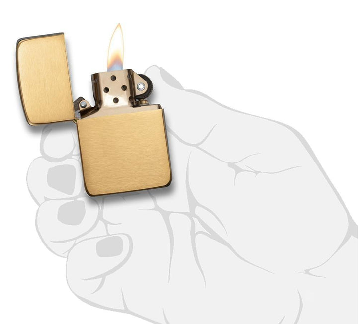 Zippo - 1941 Replica Brushed Brass Lighter with windproof flame, shown open and lit against a hand illustration background. Durable refillable gas lighter.