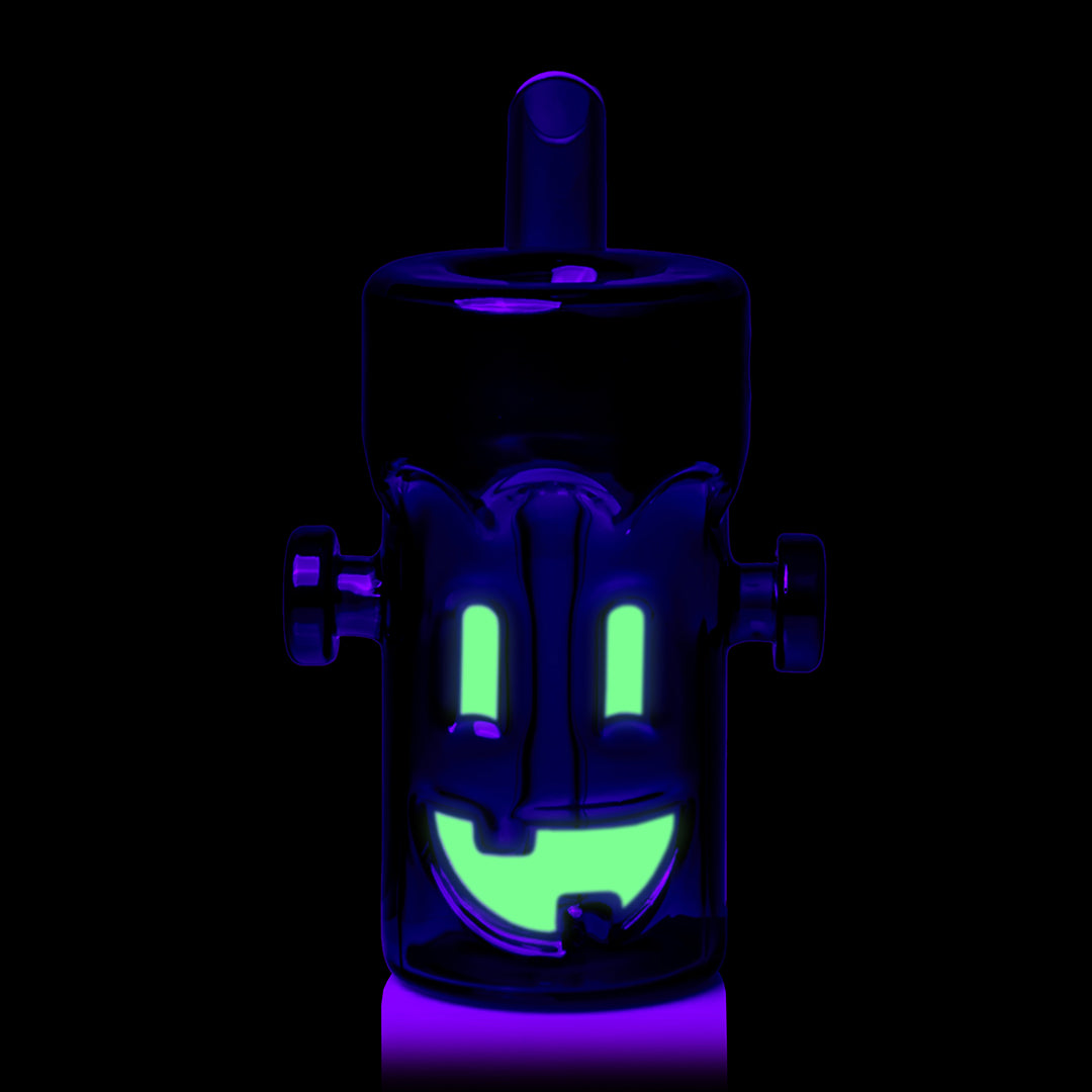 MJ Arsenal Frankenbubbler under black light, the glow-in-the-dark eyes and grin lit up green, front view