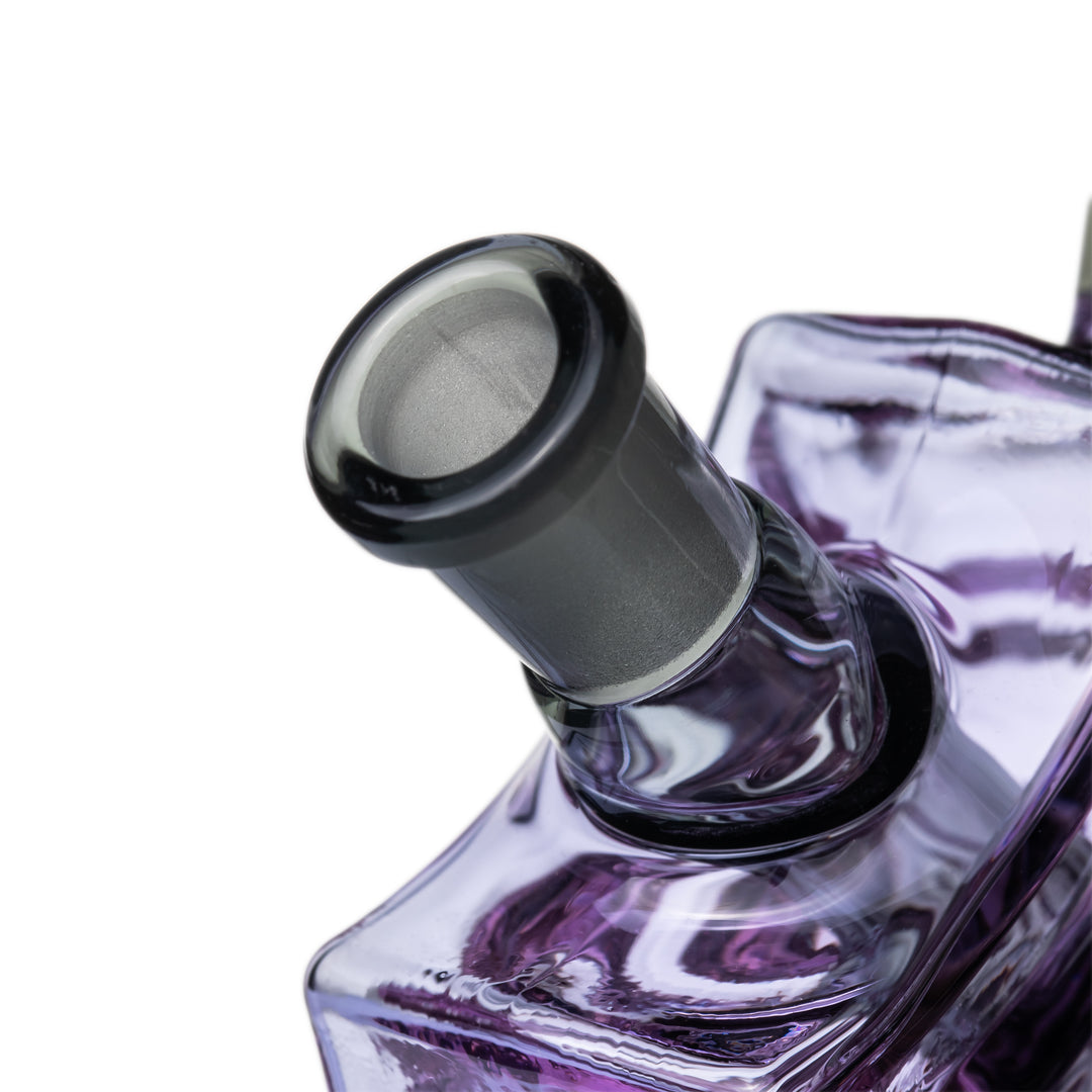 Close-up of the MJ Arsenal Nightcrawler Mini Dab Rig smoke-colored 10mm joint above the purple web