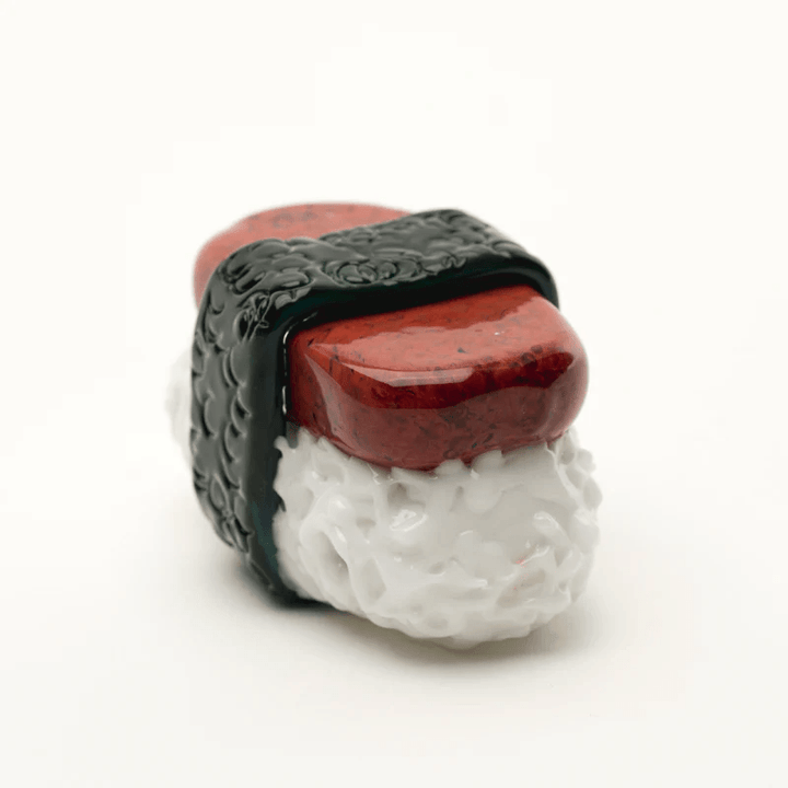 Empire Glassworks Spam Musubi Pipe shaped like sushi with realistic rice, spam, and seaweed details. Hand-crafted borosilicate glass pipe with carb and push bowl.