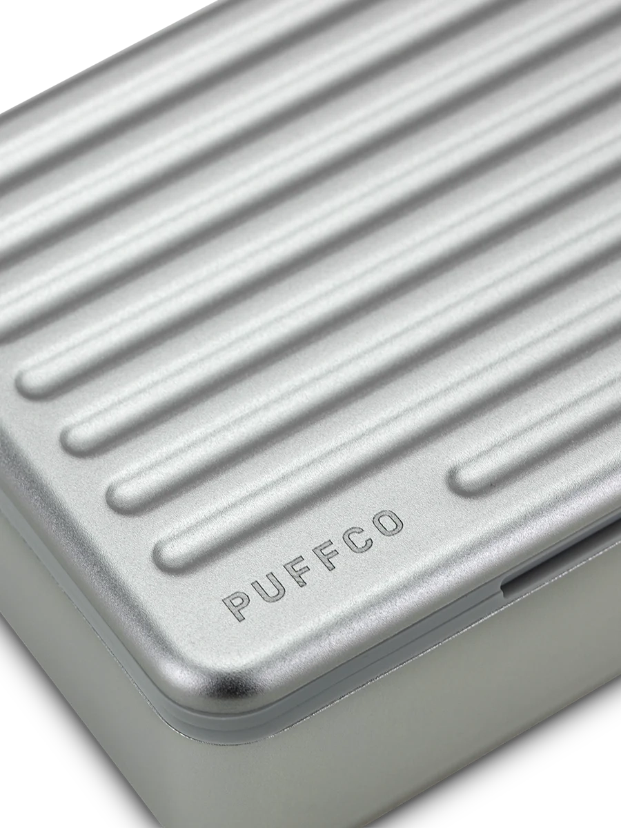 Puffco Travel Case Pearl – macro shot of ridged aluminum lid with engraved Puffco logo detail.