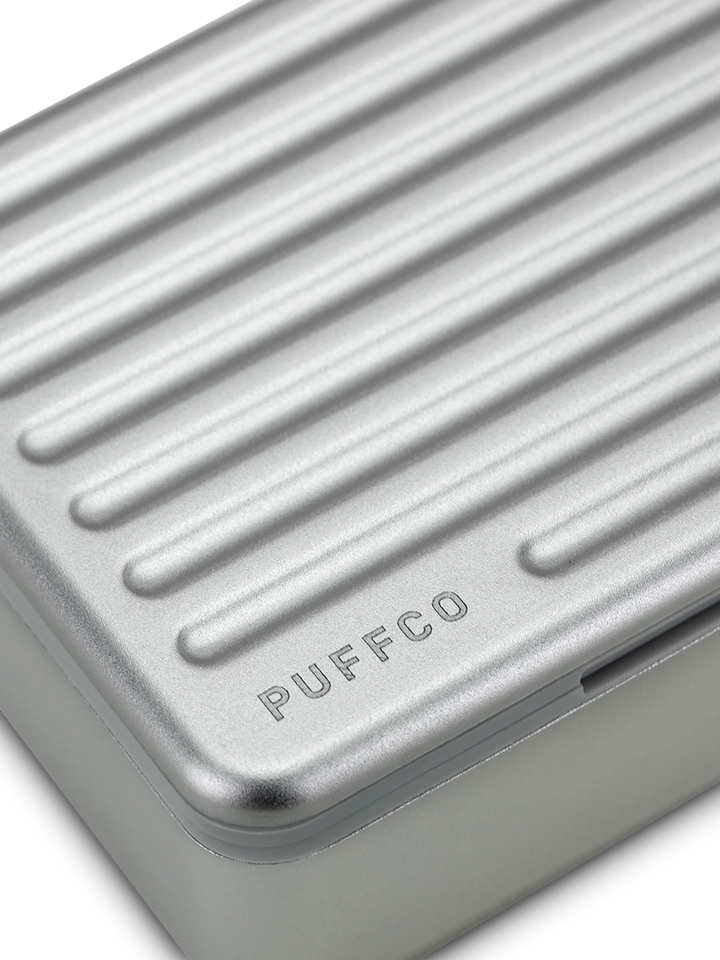 Puffco Travel Case Pearl – macro shot of ridged aluminum lid with engraved Puffco logo detail.