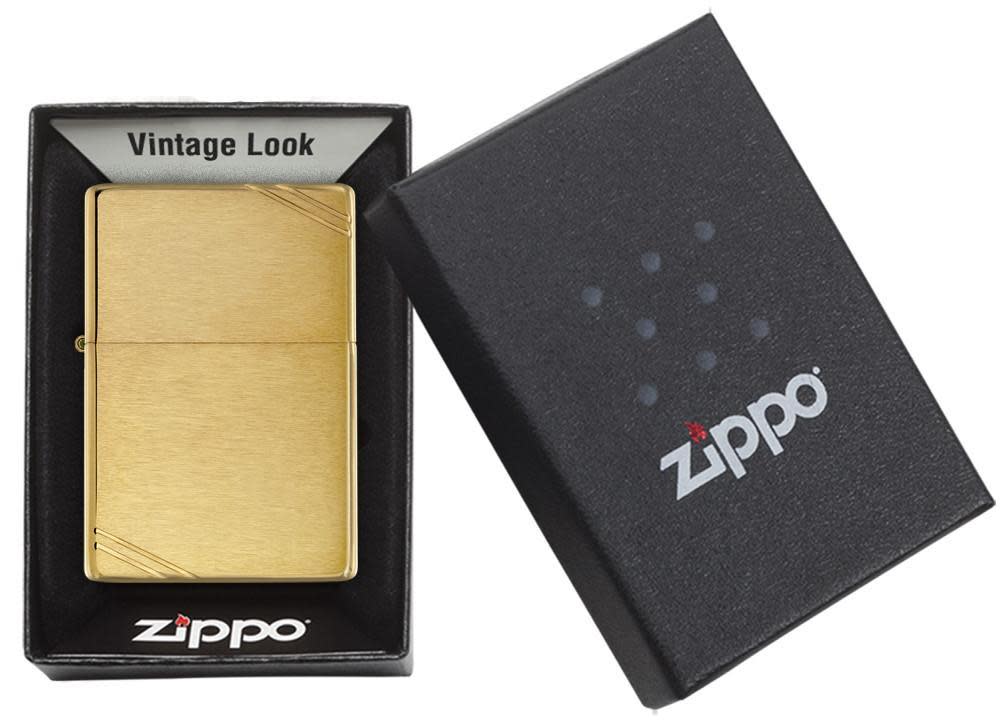 Zippo Brass Vintage lighter with brushed brass finish and diagonal slashes, displayed in original Zippo gift box with windproof design label.