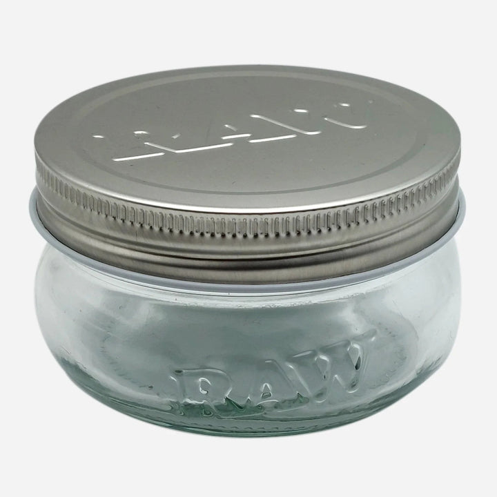 RAW 6 oz glass jar with embossed logo and metal lid, perfect for airtight and smell-proof storage of herbs or small items.