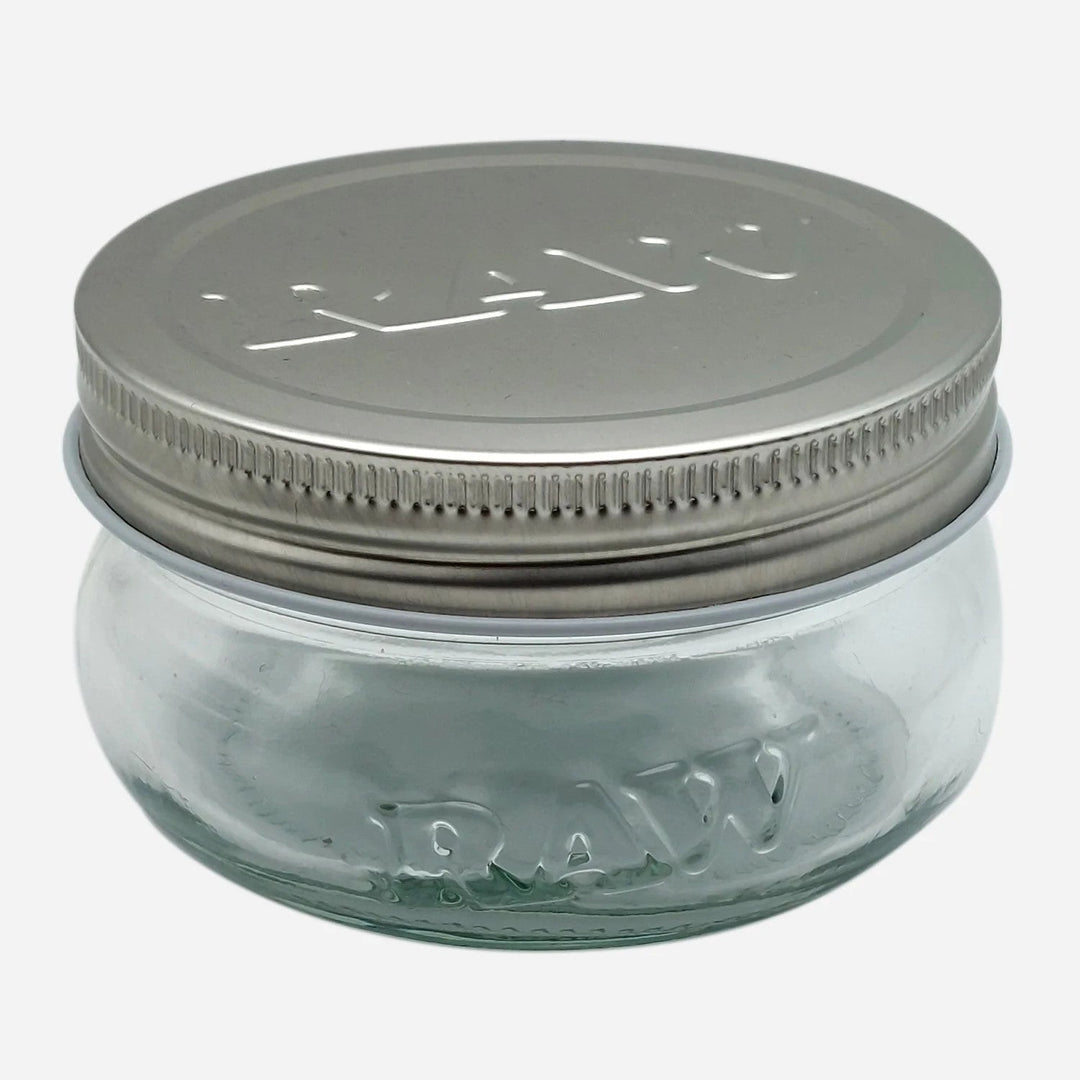 RAW 6 oz glass jar with embossed logo and metal lid, perfect for airtight and smell-proof storage of herbs or small items.