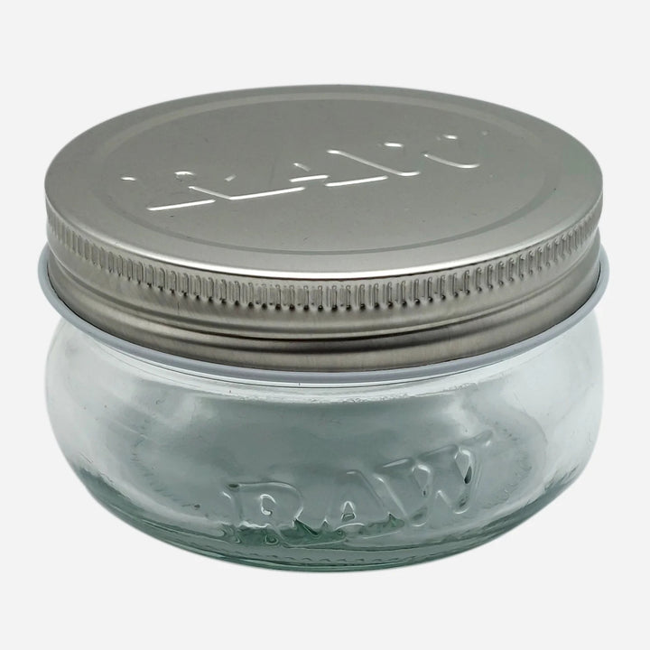 Raw 6 oz glass jar with embossed logo and metal lid, perfect for airtight and smell-proof storage of herbs or small items.